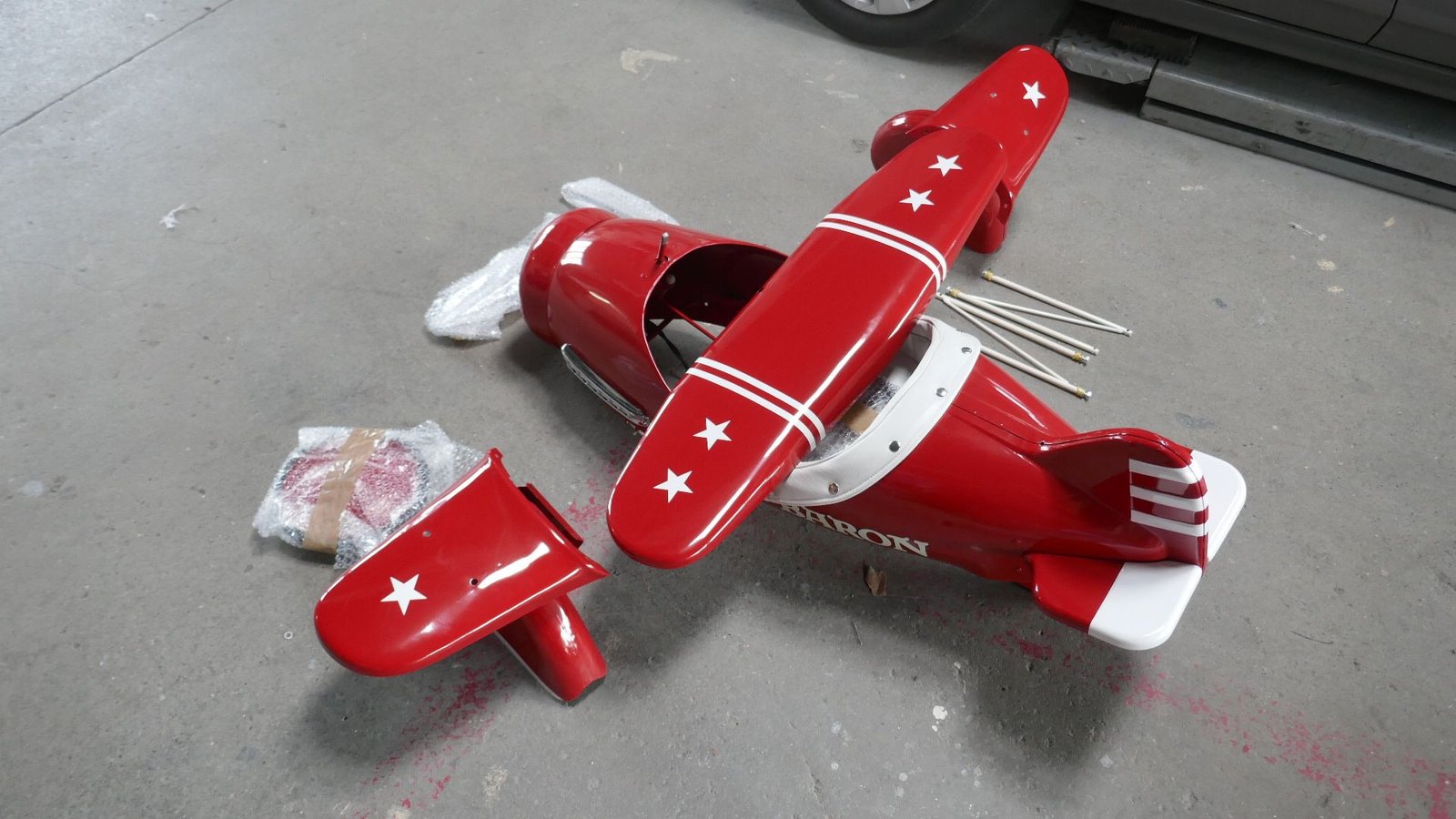 Ein rotes Spielzeugflugzeug mit weißen Sternen auf den Flügeln